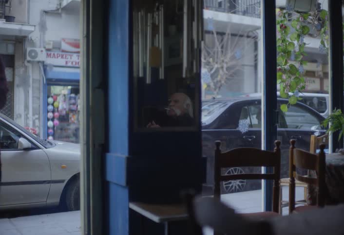 Person entering an establishment and greeting an elderly man