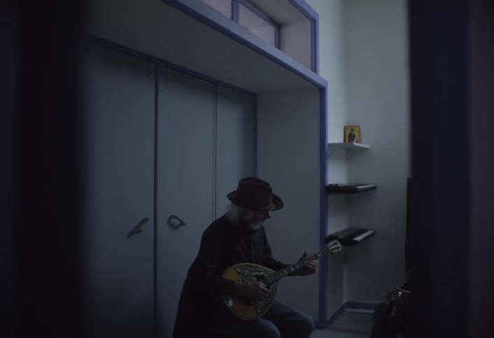 A footage of an elderly man playing a guitar