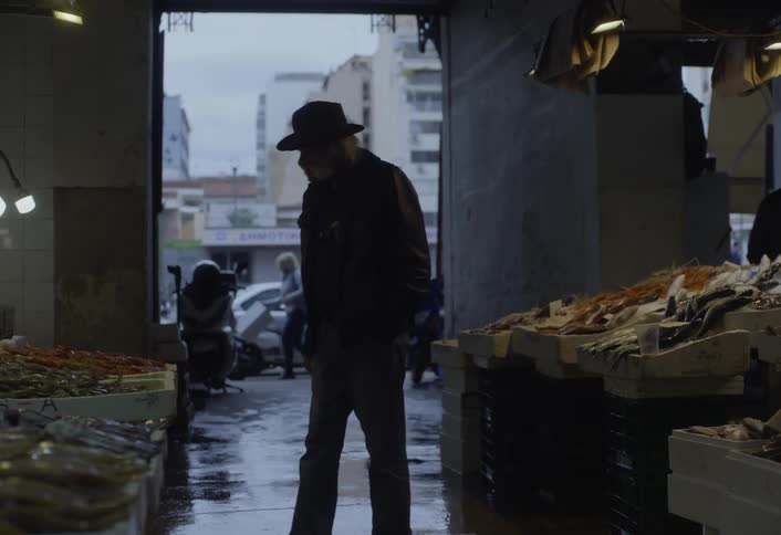 Elderly customer browses through a seafood market on an overcast day