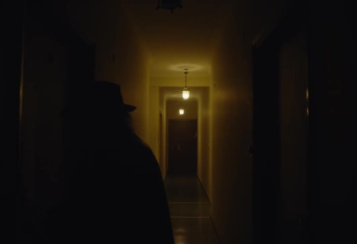 A man is walking through the hallway to his apartment door