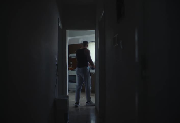 A man is walking through a hallway in his house