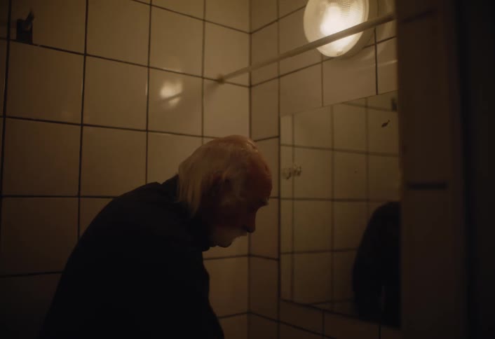 A man washes his hands and face in the bathroom