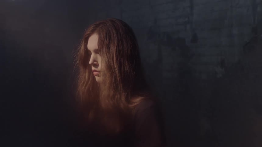 A woman in the dark and it begins to light up