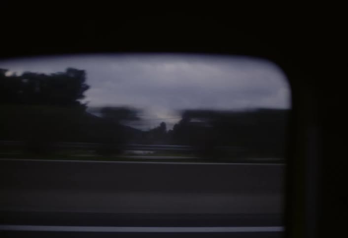 A view of a highway is captured through the windows of a moving vehicle