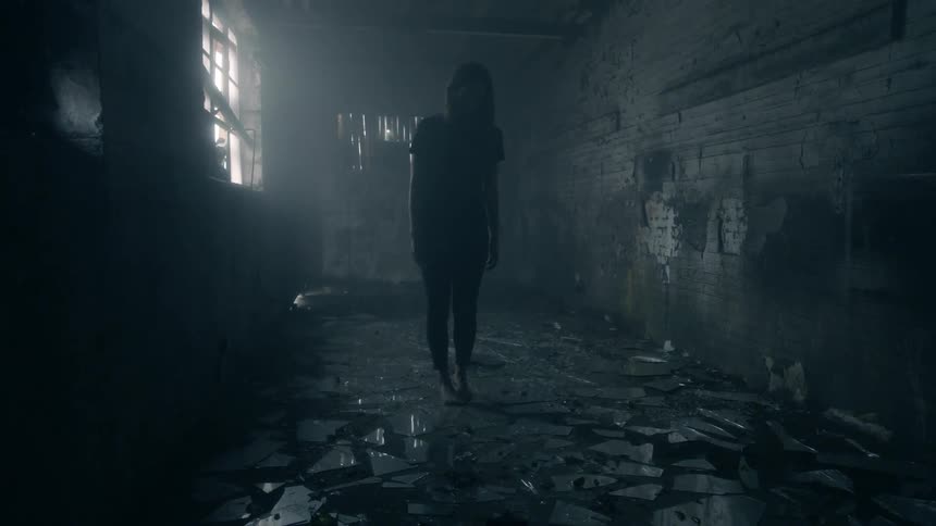 Person standing in a dark room with a floor that's constructed of geometrically shaped rocks