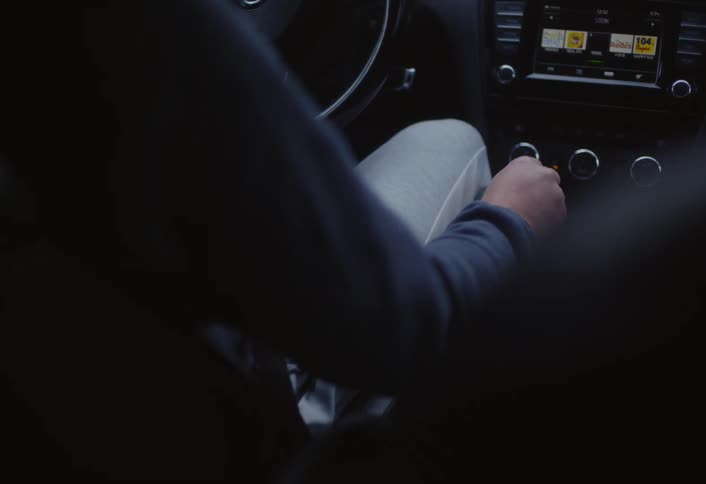 A mans hand adjusts the gear shift of a car with the focus on the act of controlling the vehicles transmission