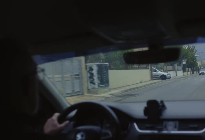 A man is driving a car through a neighborhood