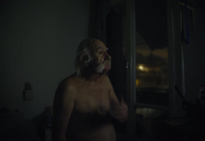 A man is standing shirtless by the balcony