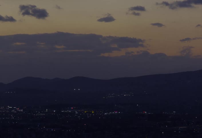 The sun is setting in the horizon of a metropolitan city