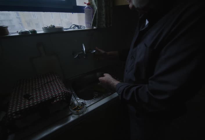 A man is washing dishes at home