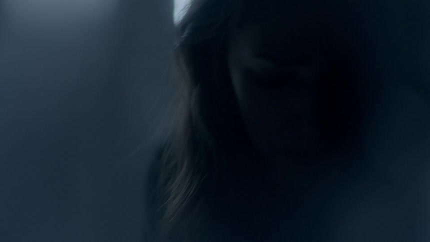 A woman is looking around in a dark room