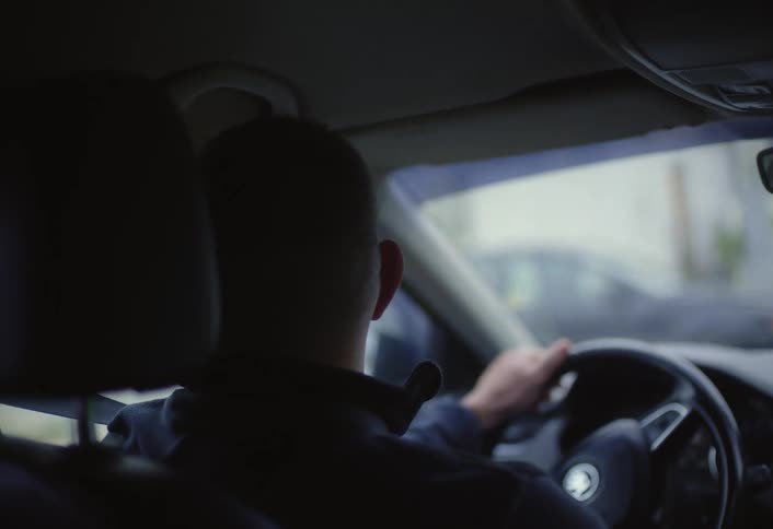 A footage of a man driving a car