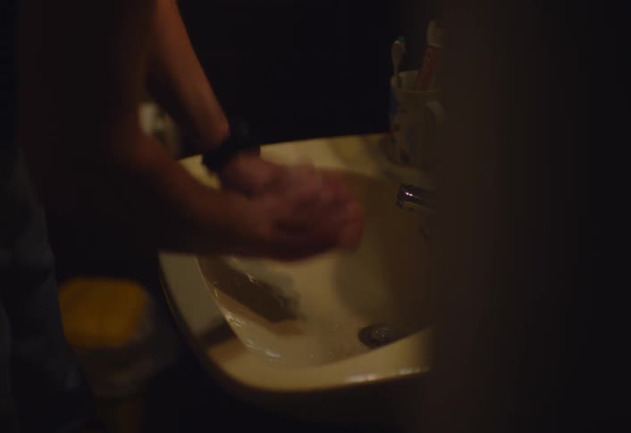 A man washes a razor in the sink