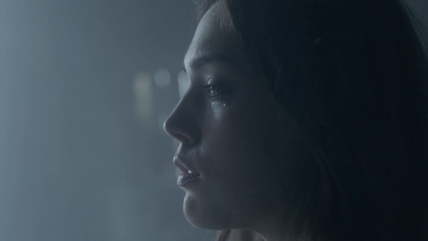 A woman is crying in a dark room