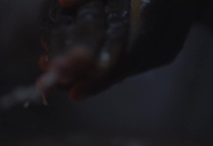 A closeup of a hand wearing a ring being washed with soap and water