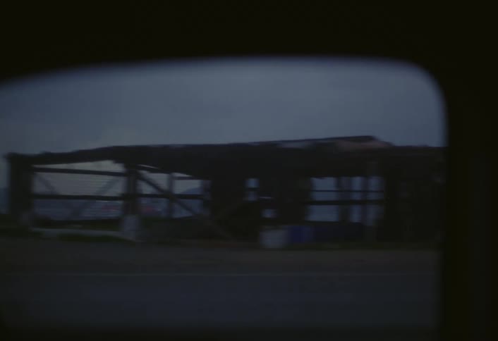 A footage of a car on a motion on a freeway beside the dockyard