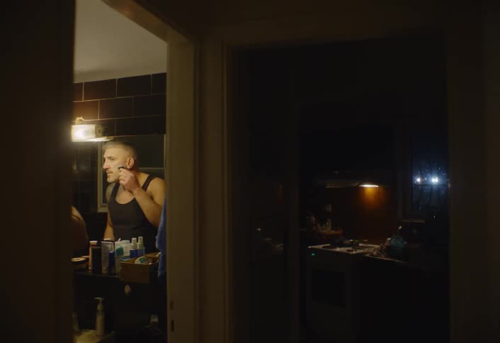 A man is shaving in the bathroom