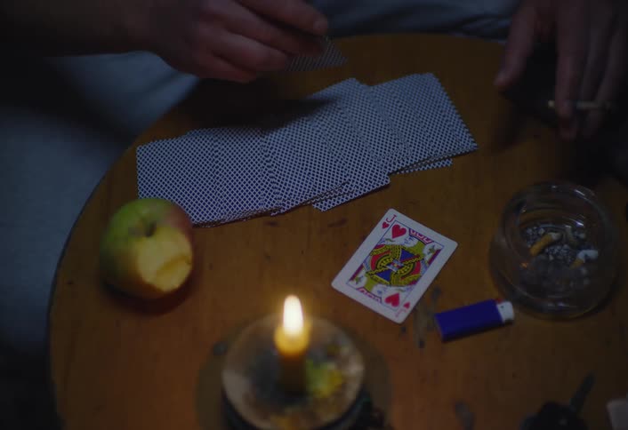 A person puts down a playing card from the deck
