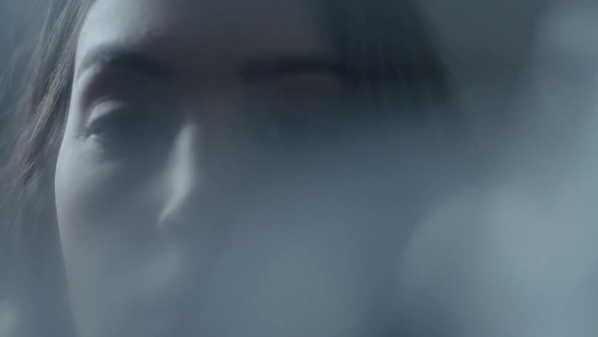 A woman stares at the camera and blinks