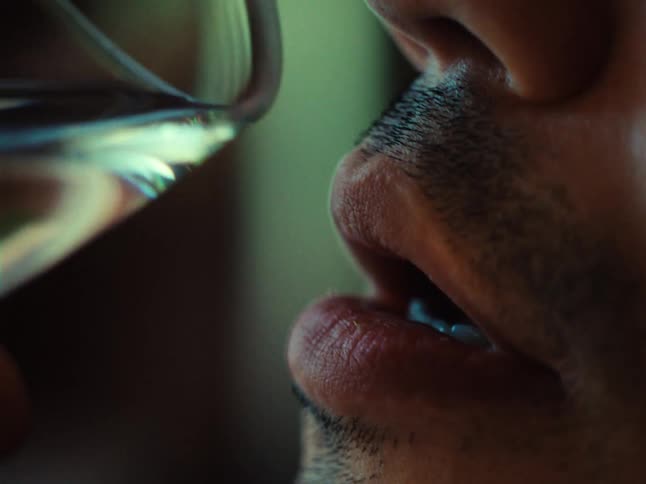 Close up of a man about to take a drink of water from a glass