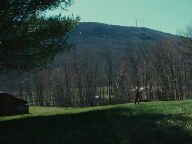 A man walks on the grass towards his home