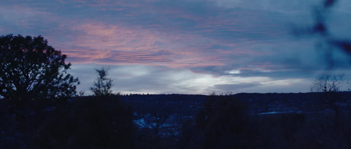 The sun is setting in the horizon of the wide landscape