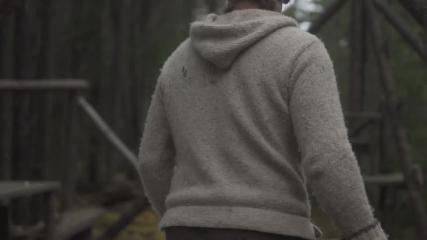 Man dragging a cloth and then a strap through the forest