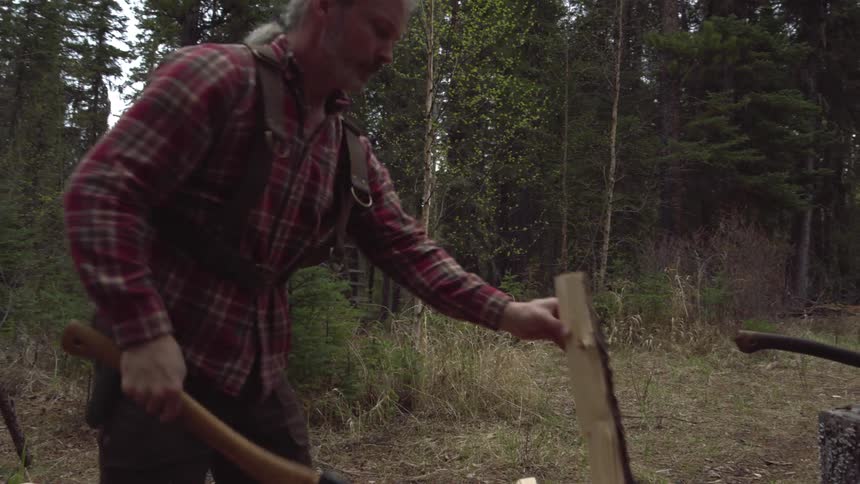 A man chops firewood with an ax