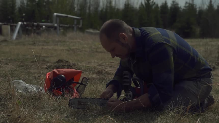 The man is repairing his chainsaw
