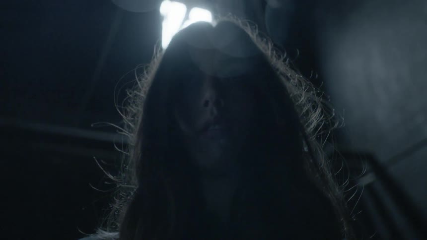 A woman walking towards the camera in a building
