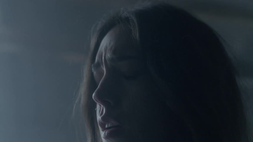 Woman cries in a dark room