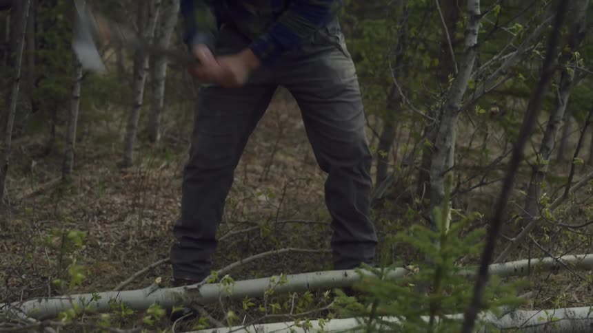 Someone hands a man an ax and he starts chopping a log