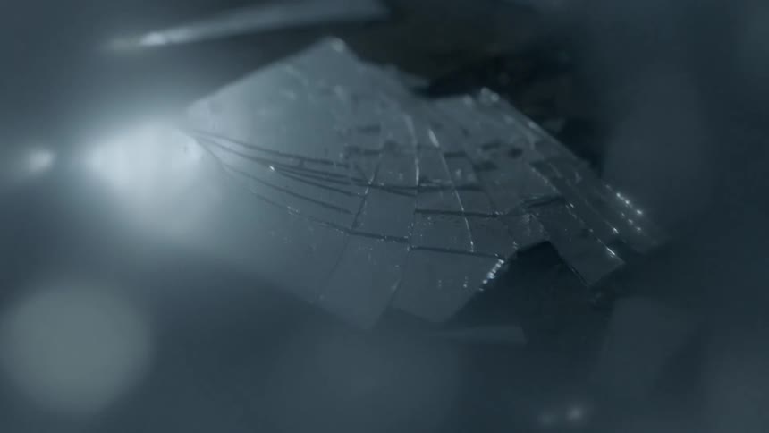 Light reflects on shards of broken glass on the ground