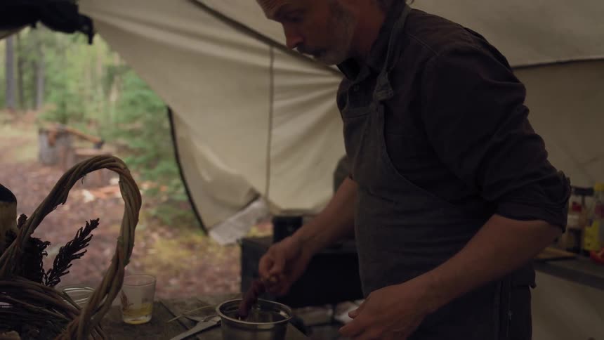 A man is cooking in his tent