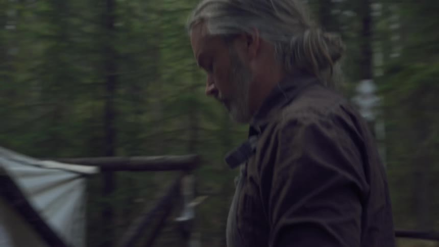 A man carries a plate of food into his tent