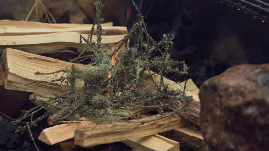 Tinder is placed on the campfire to help it grow