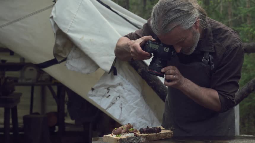 A man photographs food by the tent