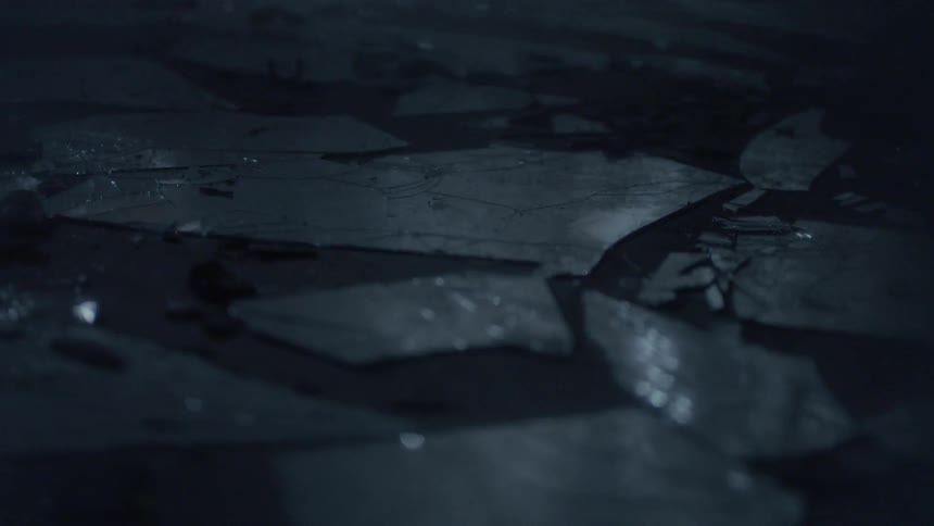 Shards of broken glass on a dirty floor