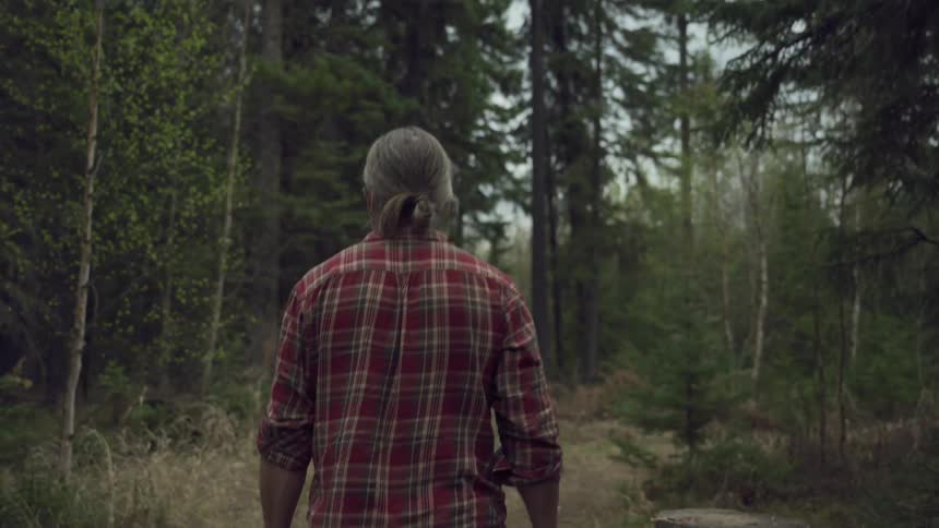 A footage of a man walking in the woods