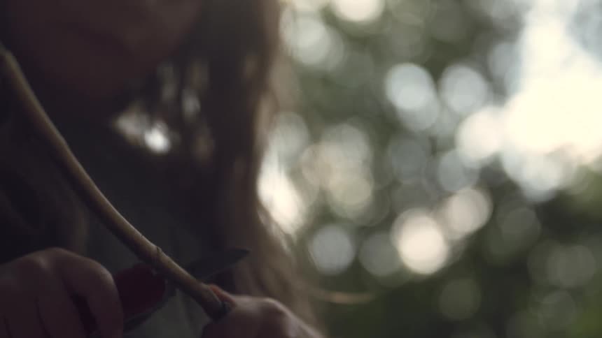 A footage of a person sharpening a stick