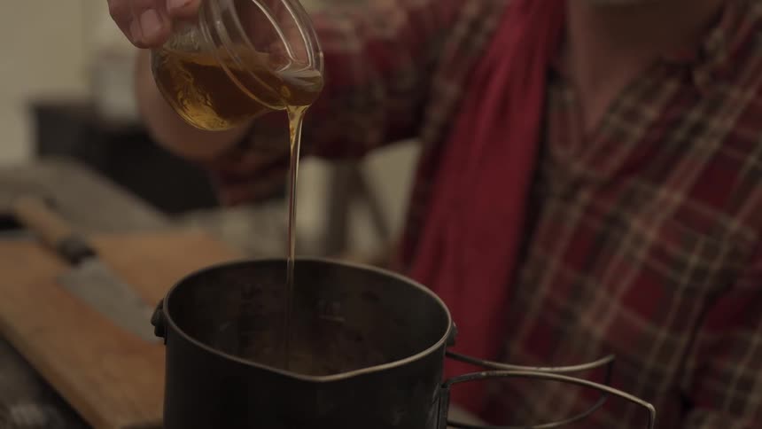 Honey being poured into a small pot