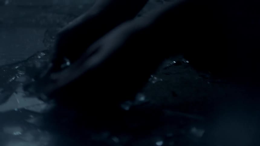 A person is picking up glass pieces on the ground