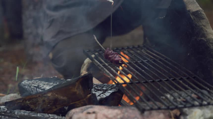A footage of a a person grilling a meat
