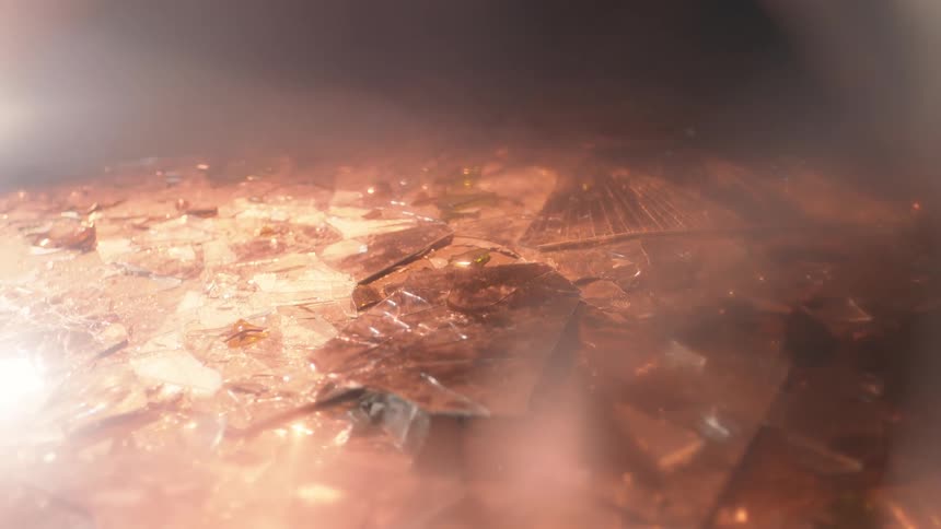 Broken glass laying on the floor and the sun shining on it
