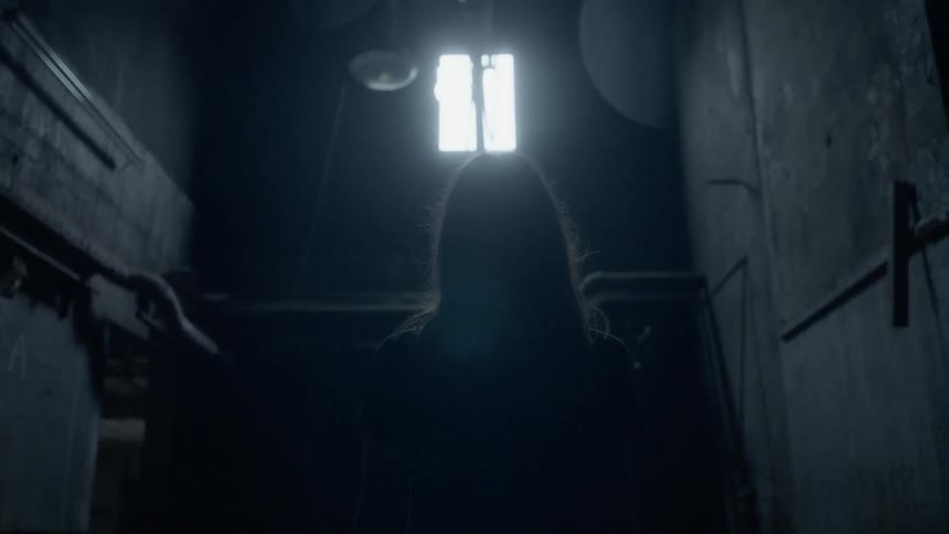 Woman walking in a dark basement