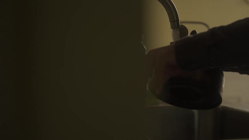 A woman fills her kettle with water