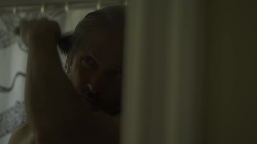 A man brushes his hair in the bathroom
