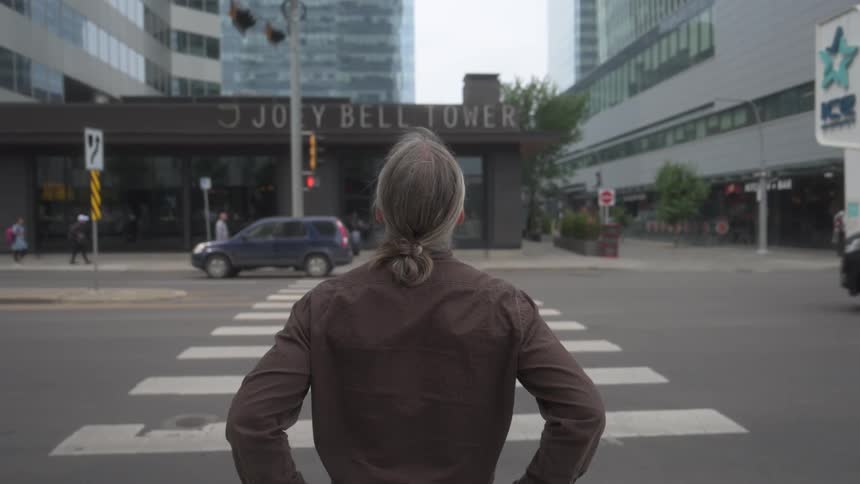 A footage of a man standing beside the road