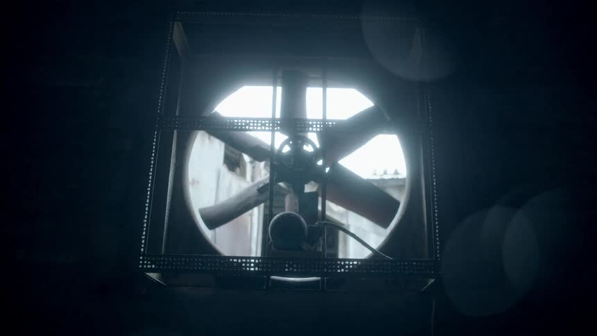 A fan slowly starts moving in a dark area