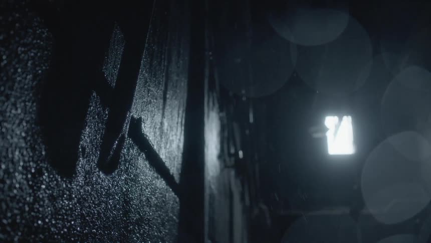 A darkened room with a ladder and water dripping